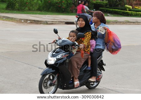 KRABI - JUL 2: A family of four ride a motor bike along a road on Jul 2, 2012 in Krabi, Thailand. The use of motorbikes as family transport is commonplace in Thailand.