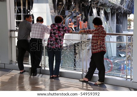 BANGKOK - MAY 23: Onlookers view burnt exterior of Zen Central World shopping mall after \'Red Shirt\' anti government protest in the Thai capital is brought to an end May 23, 2010 in Bangkok, Thailand