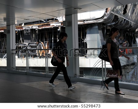 BANGKOK - MAY 23: Passersby walk past the fire damaged exterior of Zen Central World shopping mall in the aftermath of the anti government \'Red Shirt\' protest May 23, 2010 in Bangkok, Thailand