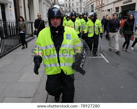 LONDON - MARCH 26: Riot police advance towards Piccadilly during anti-cuts protests March 26, 2011 in London, UK.