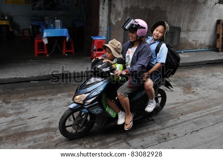 BANGKOK - AUG 16: Unidentified family school run on a motorbike during the morning rush hour on Aug 16, 2011 in Bangkok, Thailand. The use of motorbikes as family transport is commonplace in Thailand.