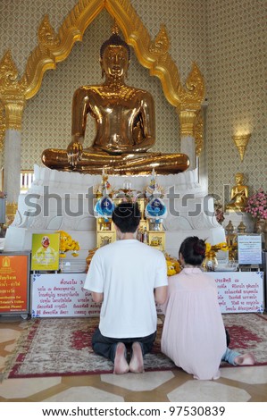 BANGKOk - MARCH 2: Unidentified merit makers pray at the world\'s largest solid gold Buddha statue housed at Wat Traimit temple on March 2, 2012 in Bangkok, Thailand.