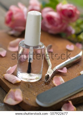 Nail varnish bottles with rose petals, selective focus