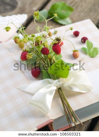 Wild strawberries bouquet with ribbon, selective focus