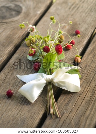 Wild strawberries bouquet with ribbon, selective focus