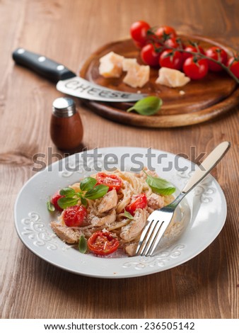 Spaghetti with chicken, cherry tomato and cheese, selective focus