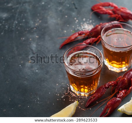 Glass of beer and lobster on dark background, selective focus