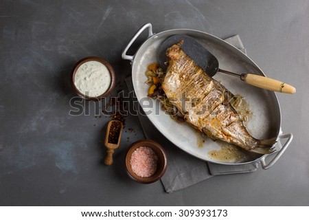 Baked fish with vegetables on vintage background, selective focus