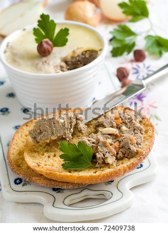 Bread with  liver pate in a white ramekin with antique silver knife.