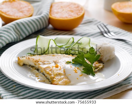 Grilled fish with cheese white sauce and cucumber