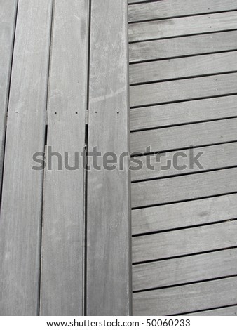 Close up view of decking material, weathered, eco friendly, grey with nails. Background, texture in two opposite directions