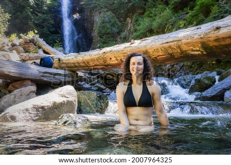 Adult Caucasian Woman hiker swimming in glacier water at Norvan Falls during hot and sunny summer day. Canadian Nature Background. Lynn Valley, North Vancouver, British Columbia, Canada. Stok fotoğraf © 