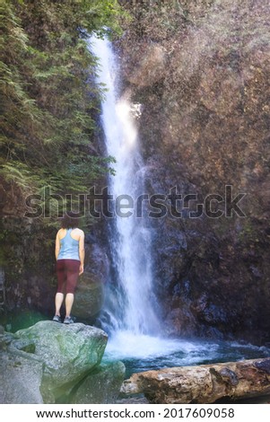 Adult Woman hiker at Norvan Falls and river stream in the natural canyon during the summer time. Canadian Nature Background. Lynn Valley, North Vancouver, British Columbia, Canada. Stok fotoğraf © 
