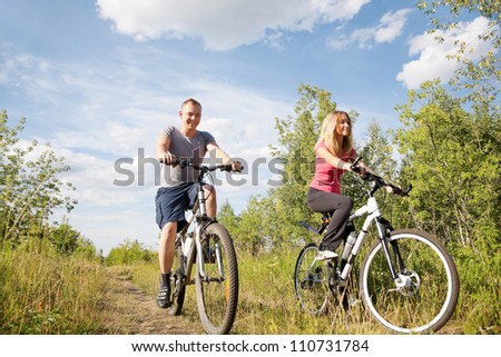 Healthy life: sporty couple riding bicycles  in the forest