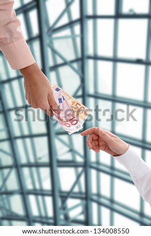 Hand handing over money to another hand