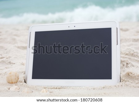 Digital tablet computer on ocean beach