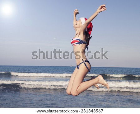 Woman jumping at the beach during christmas holiday vacation