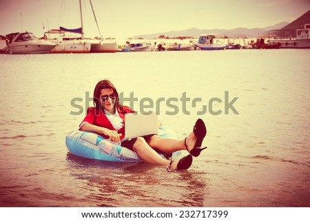 Smart business woman floating in the sea  and working on laptop