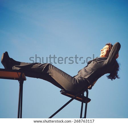 Relaxed businesswoman sitting on chair at workplace in the countryside
