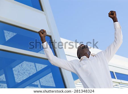 Successful man raising hands showing his business success