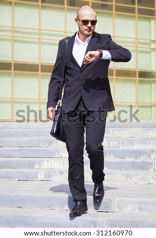 Businessman looking at watch. Hurry to work. Business time concept