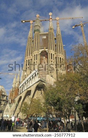 BARCELONA - DEC 26: Tourists visit The Sagrada Familia, a large Roman Catholic church designed by Catalan architect Antoni Gaudi on December 26, 2014 in Barcelona, Spain.