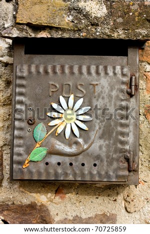 Rustic metal box with flower. Mailbox in a small town close of Siena, Italy.