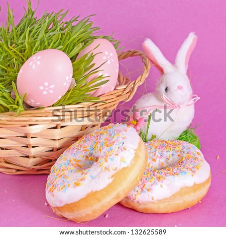 Easter eggs and rabbit with cake on lilac background