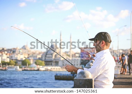 ISTANBUL - JULY 15: People fishing on Galata Bridge of Goldenhorn on July 15, 2013 in Istanbul. The bridge is well known for rod fishing in here.