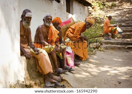 TIRUVANAMALAI, INDIA- JANUARY 15: Holy Sadhu men  in saffron color clothing  blessing in Shiva Temple. January 15, 2013 in India, Tamil Nadu, Tiruvanamalai