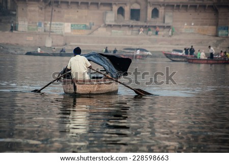 Varanasi, India - November 15, 2013: Man sailing on the boat on Ganges river during Kumbh Mela festival  on November 15, 2013
