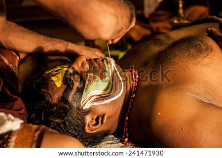 KOCHI, INDIA - DECEMBER 7 , 2012: Unidentified Kathakali exponent preparing for performance by applying face make-up on December 7, 2012 / Kathakali is the classical dance form of Kerala