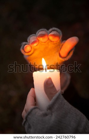 Praying Hands with candle in dark background