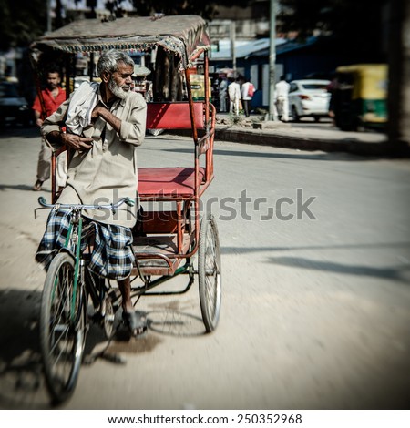 DELHI, INDIA - NOVEMBER 10: Morning on a street at November 10, 2013 in Old Delhi, India. Indian capital still uses man powered rickshaws as a usual means of transport.