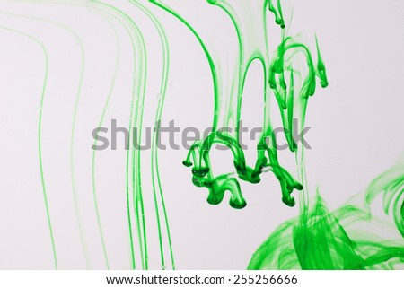 Green liquid ink  in water making abstract forms