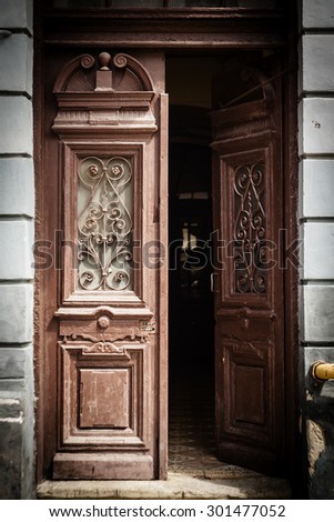 White wood bordered black door of beige stucco house