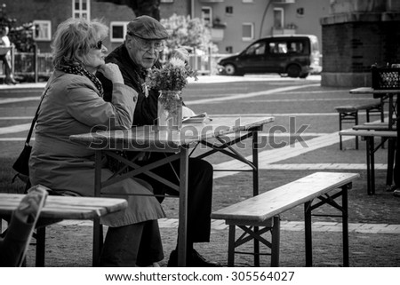 HAMBURG, GERMANY - MAY 29: cafe with people having dinner on Sunday, near the  St. Michael Cathedral  - one of the well known landmarks, on May 29, 2015 in Hamburg, Germany