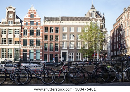 AMSTERDAM, NETHERLANDS - MAY 13, 2015: Typical bicycles, the most popular transportation system in Netherlands, parked on Amsterdam bank canal