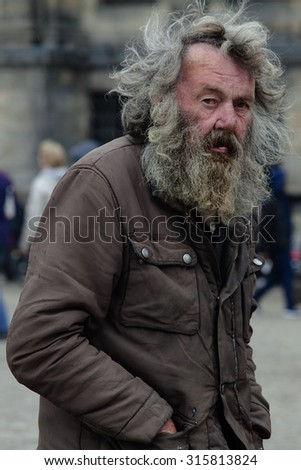 Amsterdam, The Netherlands - May 9, 2015: old poor  man walking by the streets of  Amsterdam on May 9, 2015 in Amsterdam, Holland