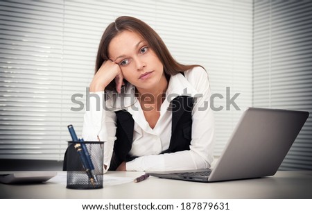 tired young business woman with laptop computer at the office