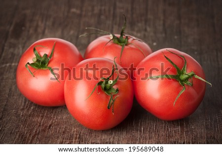 whole tomatoes on brown textured wood