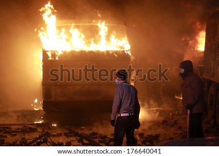 Man on the background of a burning bus. Kyiv, Ukraine, January 19, 2014