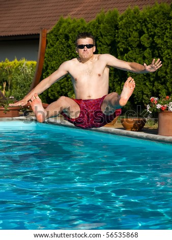 young man is jumping into pool