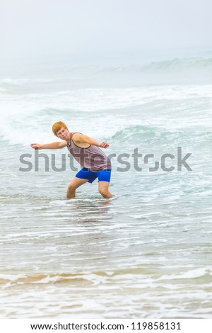 boy has fun throwing stones at the beach