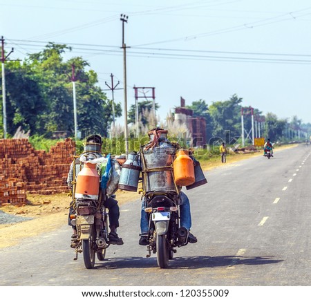 RAJASTHAN, INDIA - OCTOBER 18: men riding motorbike with cans of milk on October 18, 2012 in Rajasthan, India. These motorized milkman reach also the small villages.