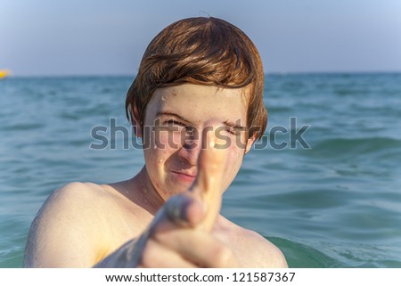 boy with red hair is enjoying the clear warm water at the beautiful beach
