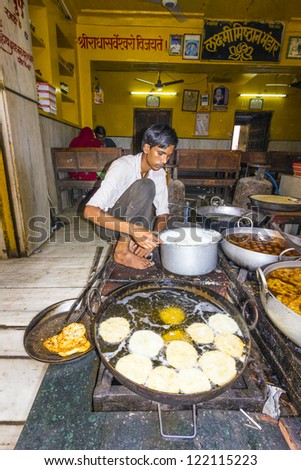 PUSHKAR, INDIA - OCTOBER 20: Local man prepares bakery in a pan on November 20,2012 in Pushkar, india. Pan cooking in India is common and mainly propane gas is used as heating material.