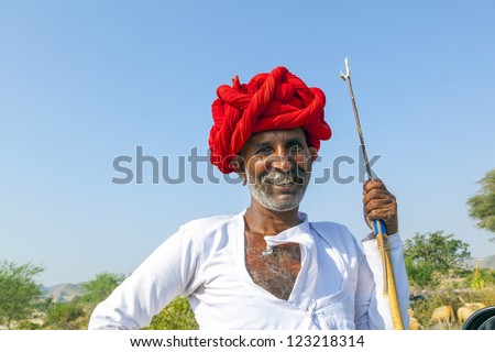 PUSHKAR, INDIA - OCTOBER 22: A Rajasthani tribal man wearing traditional colorful turban and loves to pose  at the annual Pushkar Cattle Fair on October 22, 2012 in Pushkar, Rajasthan, India.