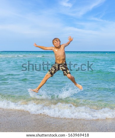 boy jumps in the surf of the crystal clear ocean