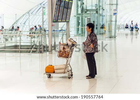BANGKOK - JAN 5: woman waits with baggage cart at Suvarnabhumi International Airport on January 5, 2010 in Bangkok, Thailand. The airport is handling about 45 million passengers annually.